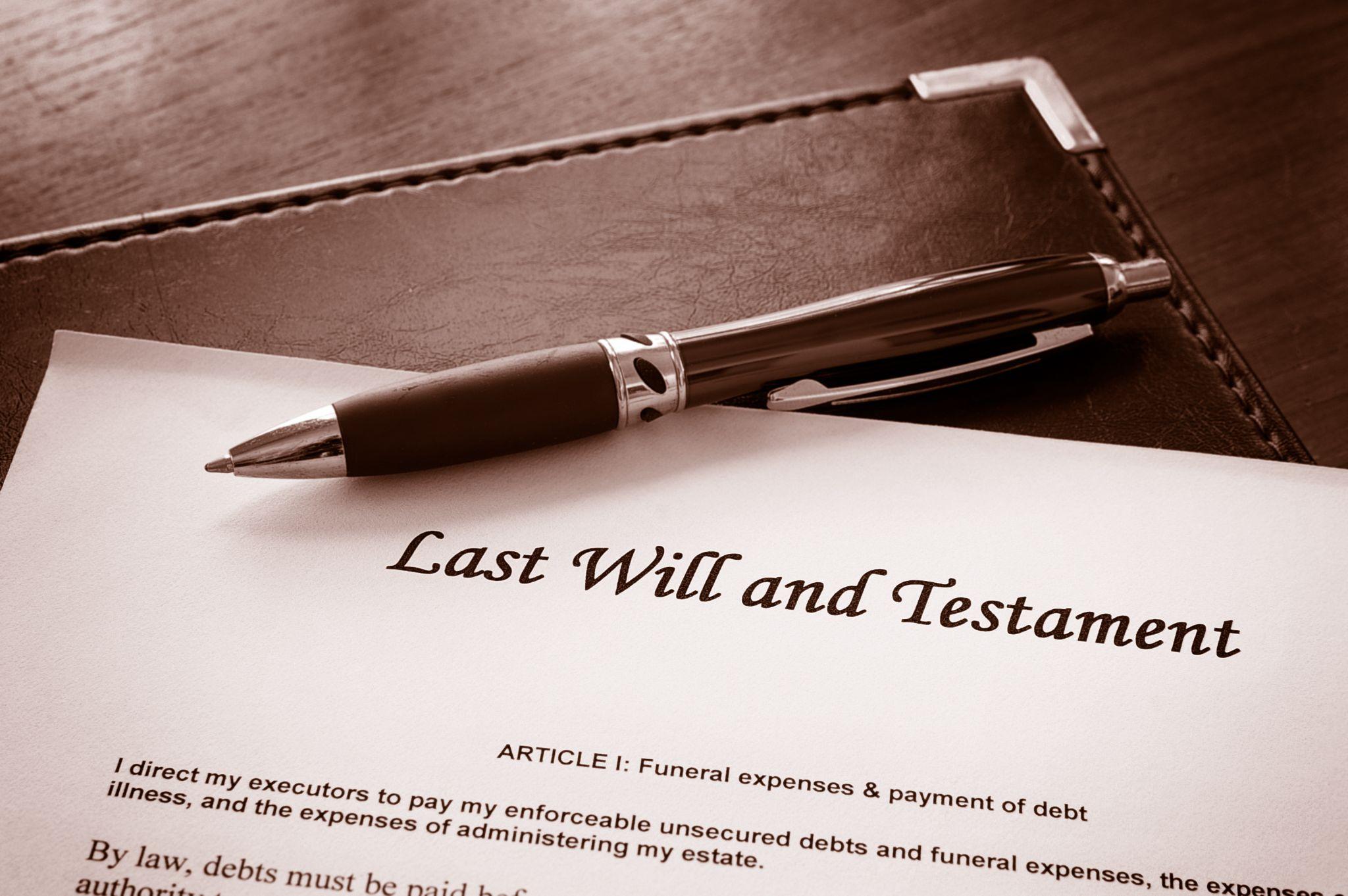 A close-up of a pen on a document titled "Last Will and Testament," highlighting the connection between estate planning and real estate trusts